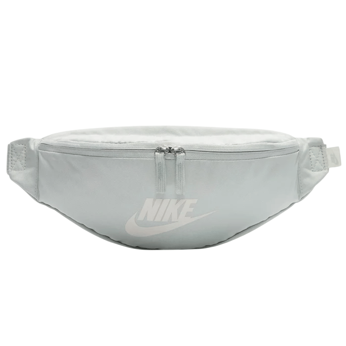 A light gray Nike fanny pack featuring a zipper closure and the Nike logo on the front.