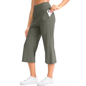 High-waisted capri leggings in olive green with side pocket, styled with white sneakers.