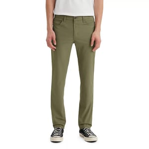Levi's 511 Slim Tech Pants in olive color feature a slim fit design with a classic 5-pocket style, belt loops, and a button-zip closure, paired with black and white sneakers.