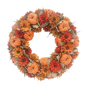 A decorative wreath featuring orange and red flowers, small pumpkins, and green leaves, arranged in a circular pattern for a fall-themed display.