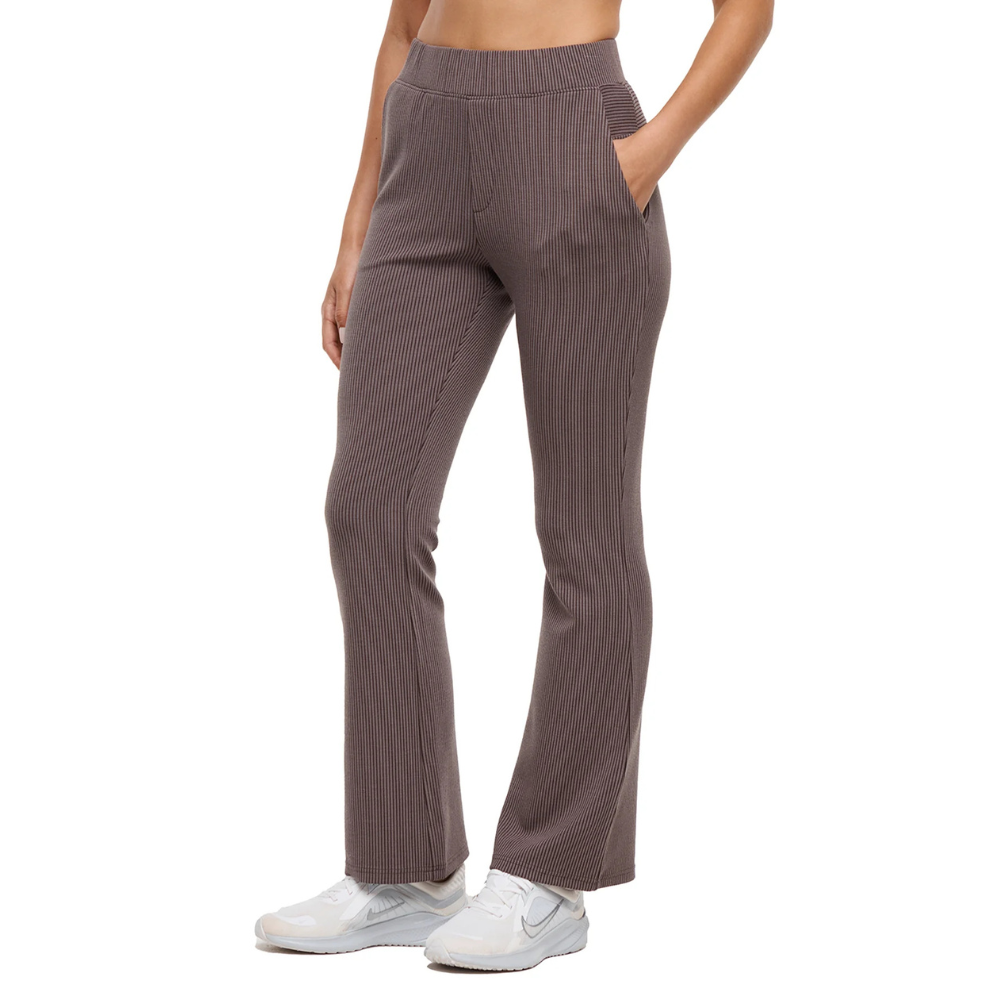 Brown flared ribbed pants with an elastic waistband and side pockets, paired with white sneakers.