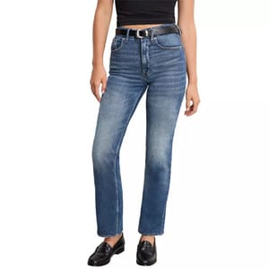 A person is wearing blue jeans, a black belt, and black loafers. The jeans have a straight-leg fit and a mid-rise waist, paired with a black cropped top.