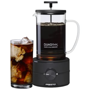 Dorothy Rapid Cold Brewer by Presto, featuring a glass carafe with a handle, plunger, and a black base with a dial, is shown beside a glass of iced coffee with swirling cream.