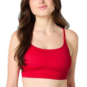 A woman wearing a red ribbed crop top with thin shoulder straps.