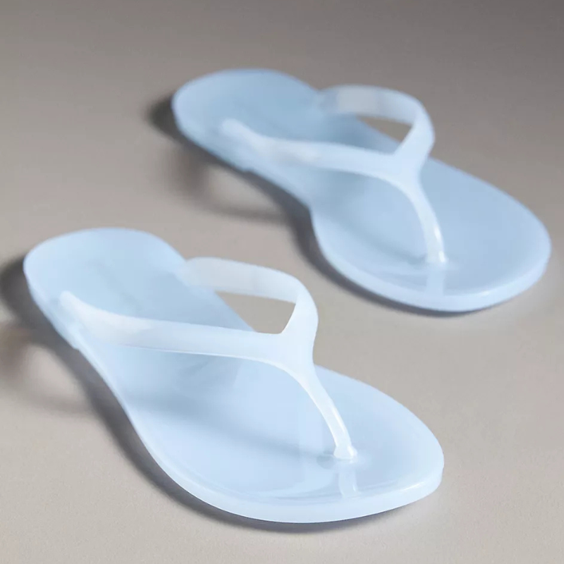 Light blue translucent flip-flops with simple design and thong straps are displayed on a neutral background.