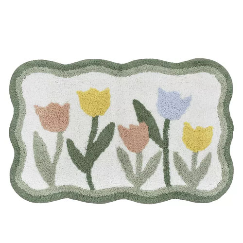 A rectangular rug with a scalloped border features a design of pastel tulips in yellow, blue, and pink on a white background.