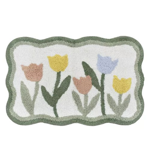 A rectangular rug with a scalloped border features a design of pastel tulips in yellow, blue, and pink on a white background.