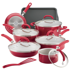 Red nonstick cookware set includes pots, pans, lids, a cookie sheet, and a spatula. The set features rubberized handles and glass lids, designed for various cooking needs.
