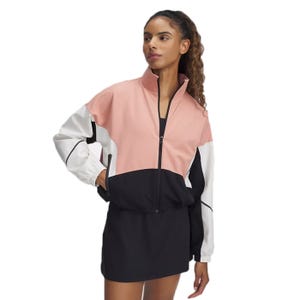 A woman is wearing a color-blocked jacket with pink, white, and black sections, paired with a black skirt.