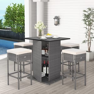 A wicker outdoor bar set with a high table and storage shelves, accompanied by two bar stools with light cushions.