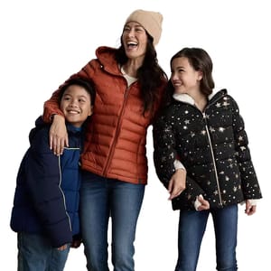 Three people are wearing winter jackets: a brown puffer jacket, a black jacket with star patterns, and a blue puffer jacket. One person is also wearing a beige beanie.