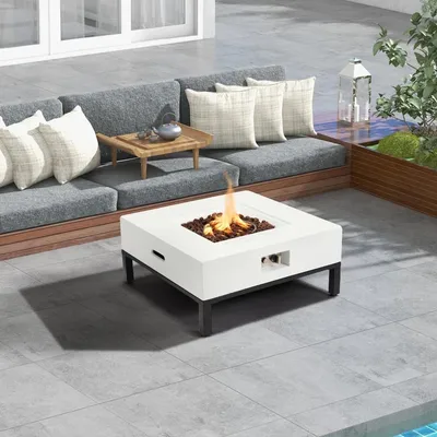Outdoor patio setup with a gray cushioned L-shaped sofa, white fire pit table with black legs and built-in handle, and a small wooden tray table.
