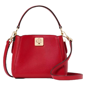 The Kate Spade Phoebe Leather Crossbody is a compact, red pebbled leather bag with gold-tone hardware. It features a top handle, detachable crossbody strap, and a front gold clasp closure.