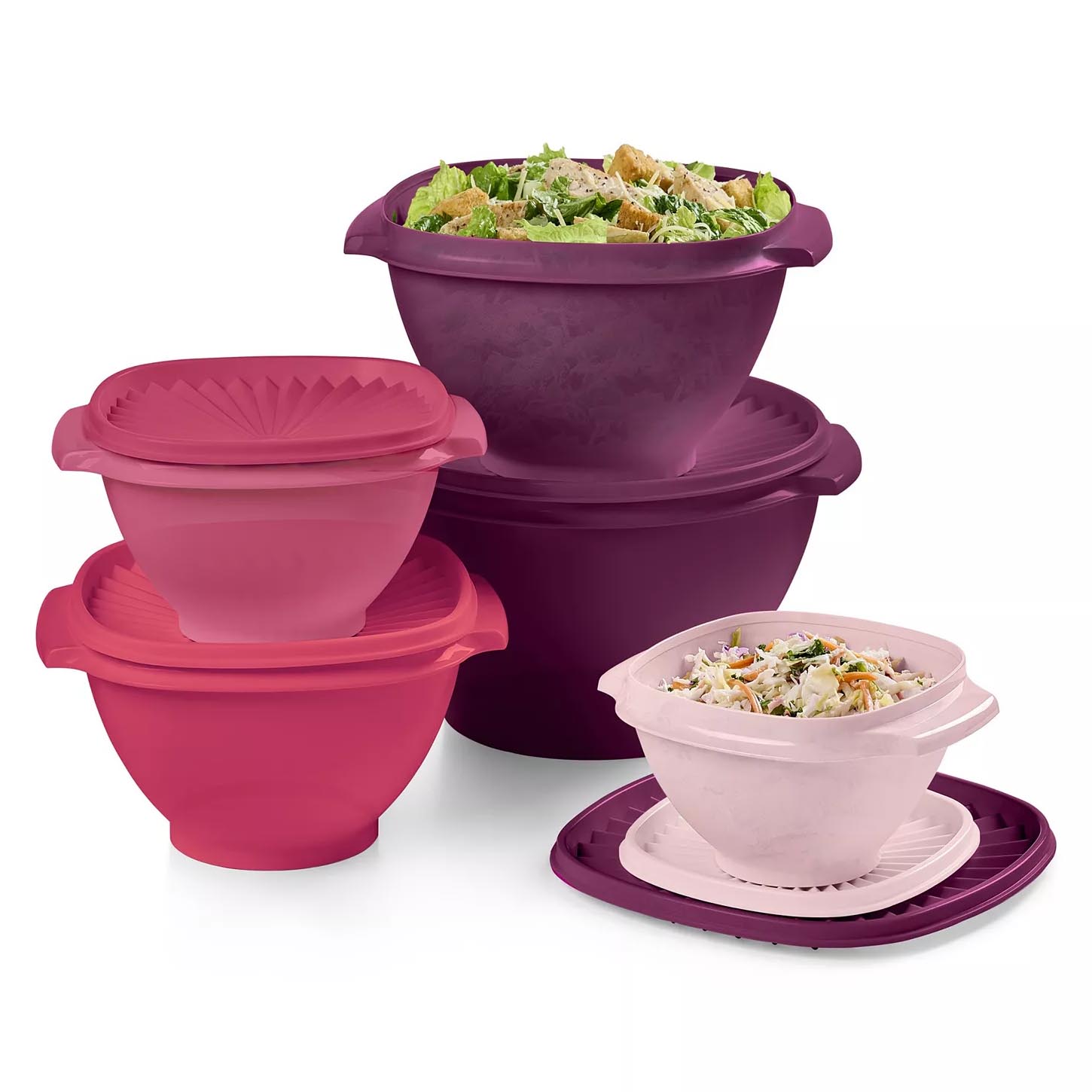A set of colorful plastic mixing bowls with lids in various sizes, featuring vibrant shades of purple and pink. Some bowls contain salads.