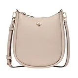 A beige leather crossbody bag with a gold spade logo, featuring an adjustable strap and gold hardware.