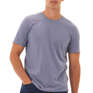 A man is wearing a light purple short-sleeve T-shirt and dark blue jeans.