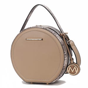 Round MKF faux-leather crossbody bag featuring a taupe front, snake print sides, and gold hardware, including an \“M\“ charm. It has a single top handle and a detachable shoulder strap.