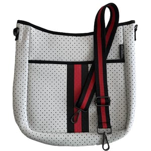 A white perforated crossbody bag with black and red stripes and a matching adjustable shoulder strap.