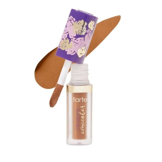 Tarte concealer with a floral-patterned cap and an applicator wand, shown with a streak of brown concealer swatch.