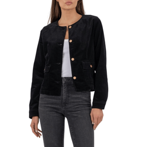 A woman is wearing a black velvet button-up jacket over a white top, paired with high-waisted dark gray jeans and black pointed-toe heels.