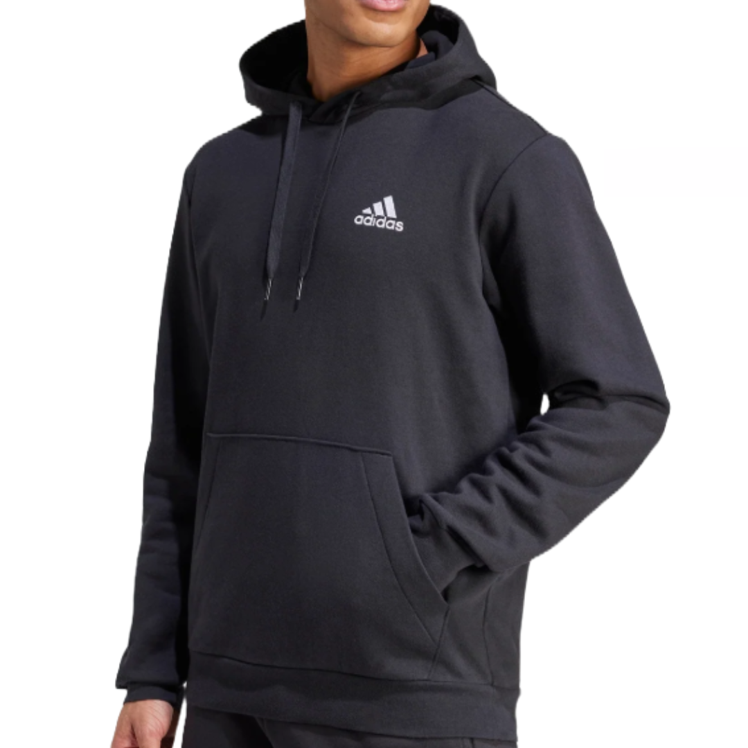 A person is wearing a black Adidas hoodie with the brand logo on the front. The hoodie features a kangaroo pocket and drawstrings.