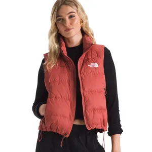A woman is wearing a red North Face puffer vest over a black long-sleeve top. The vest features a logo on the chest and a drawstring hem.