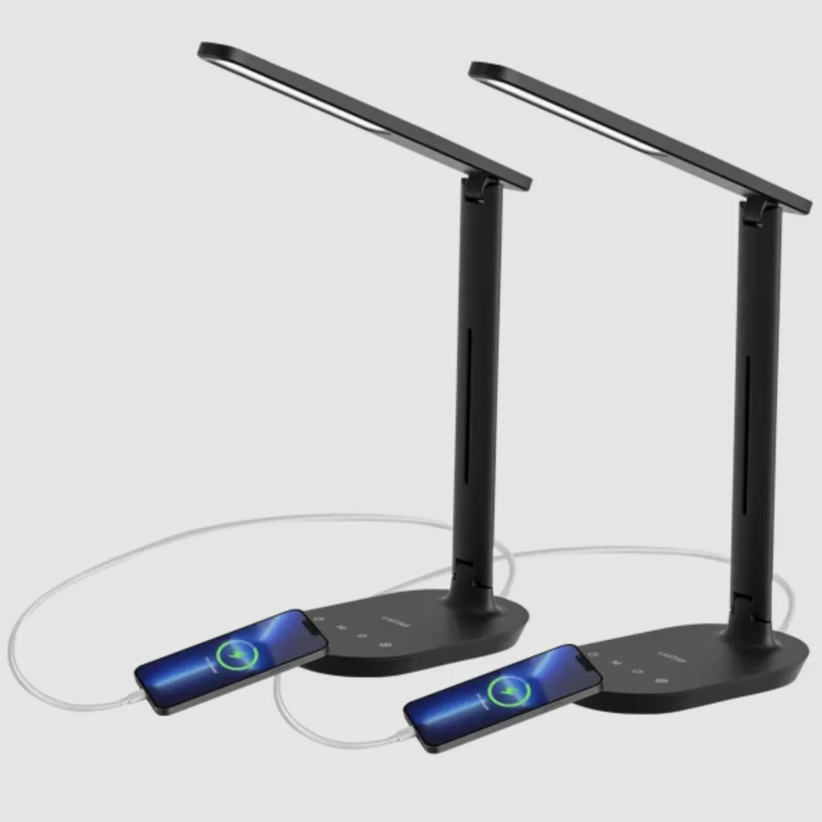 Two black desk lamps with adjustable arms and built-in wireless charging pads, connected to smartphones via charging cables.