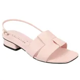 A pastel pink sandal with a low block heel, open toe, and slingback strap. It features a crisscross front design with a subtle bow accent.