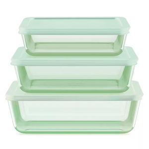 A set of three rectangular glass food storage containers with light green lids, stacked on top of each other.