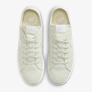 A pair of off-white sneakers with white laces and branding on the tongue and insole.