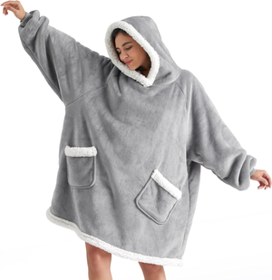 Gray oversized wearable blanket with a hood, featuring white fleece trim and two front pockets.