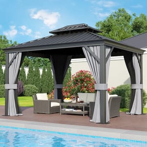 12' x 10' metal gazebo with a dark roof, light and dark curtains, placed on a poolside deck. Contains wicker furniture including cushioned chairs and a coffee table, surrounded by bushes and trees.