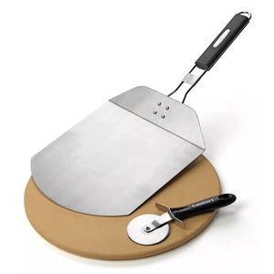A set of pizza tools including a large metal pizza peel with a black handle, a round pizza stone, and a pizza cutter with a circular blade and black handle.