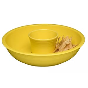 A yellow chip and dip tray with a built-in central cup, holding some tortilla chips on the side.