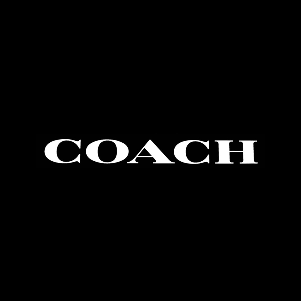 The logo of COACH, a luxury fashion brand known for leather goods, is displayed against a black background.