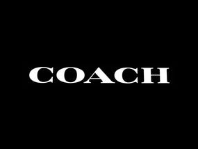 The logo of COACH, a luxury fashion brand known for leather goods, is displayed against a black background.