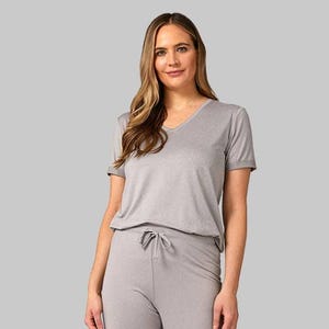 A woman wearing a gray V-neck T-shirt paired with matching drawstring pants.