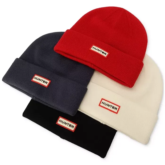 Four knitted beanies in red, gray, white, and black, each featuring the \“HUNTER\“ logo on the front.