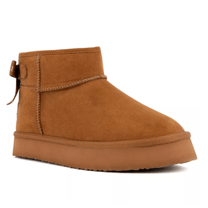 Juicy Couture Platform Cozy Boots feature a tan suede finish, platform sole, and ankle-high design with a decorative bow at the back.