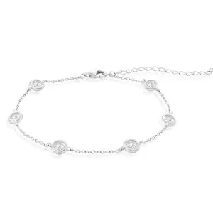 A silver bracelet with a delicate chain design features evenly spaced round charms, each set with a small sparkling stone, and includes an adjustable clasp for sizing.