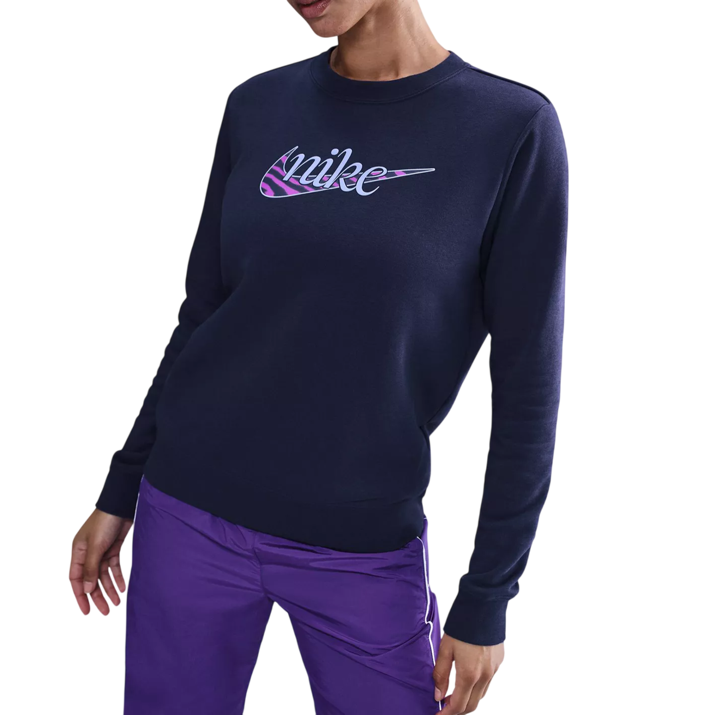 A person wearing a navy sweatshirt with a colorful \“nike\“ logo, paired with purple pants.
