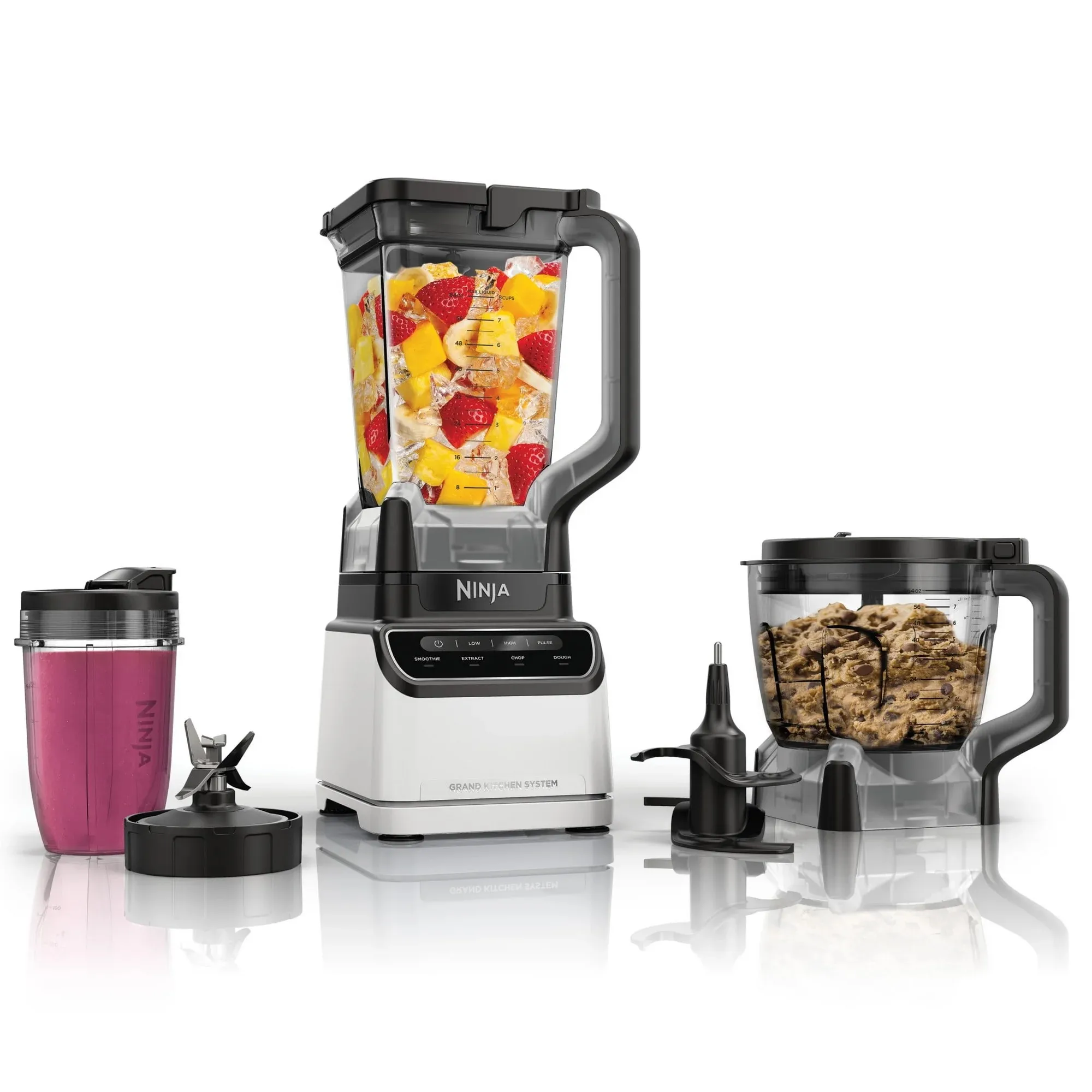 The Ninja Grand Kitchen Blender System includes a blender with a pitcher filled with fruits, a food processor bowl, a single-serve cup with a lid, and an array of interchangeable blades and attachments for blending and processing.