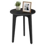 A round black wooden side table with three legs, featuring a potted plant and a framed black-and-white photo on top.