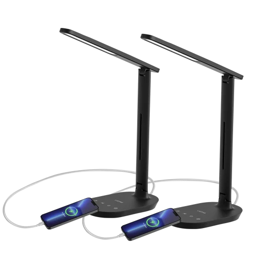 Two black LED desk lamps with adjustable arms, each featuring a USB charging port at the base connected to a smartphone. Touch controls for light settings are visible on the base.