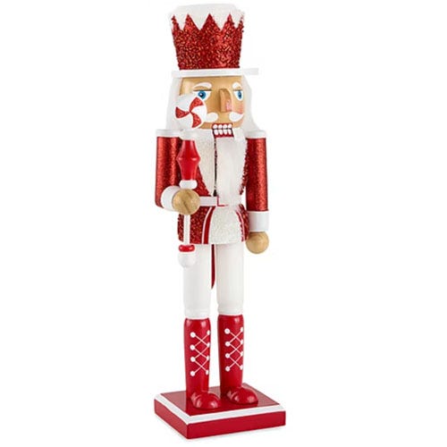 Red and white nutcracker with a glittery crown and boots, holding a red candle.