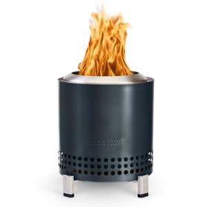 The Solo Stove Mesa XL Fire Pit is a sleek, portable fire pit with a black finish and a stainless steel rim, featuring a vented design for efficient airflow and smokeless burning. It has sturdy metal legs for stability.