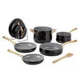 Cookware set with black non-stick pots and pans featuring gold handles, a wooden spatula, and a metal rack for organization.