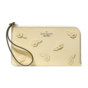 A cream-colored wristlet wallet with embossed floral designs and a wrist strap, featuring the Kate Spade New York logo.
