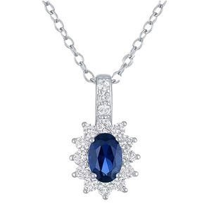 A silver necklace features a pendant with an oval blue gemstone, surrounded by small clear stones in a floral pattern.