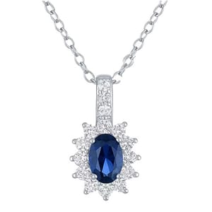 A silver necklace features a pendant with an oval blue gemstone, surrounded by small clear stones in a floral pattern.
